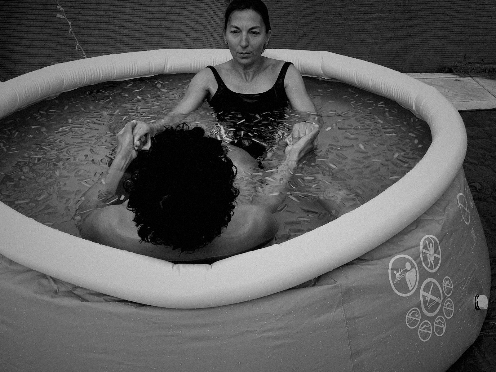 Dos participantes dentro del agua con hielo, cogidos de las manos