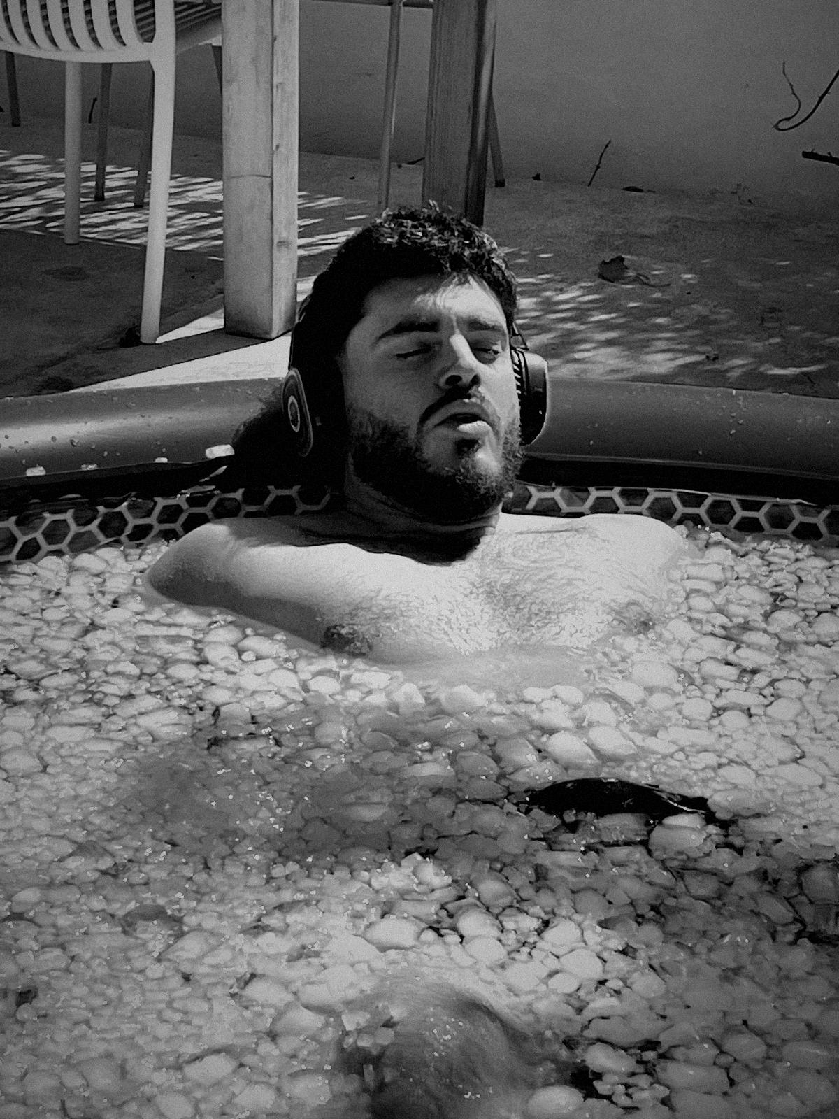 Un participante respira con auriculares dentro de una piscina de hielo