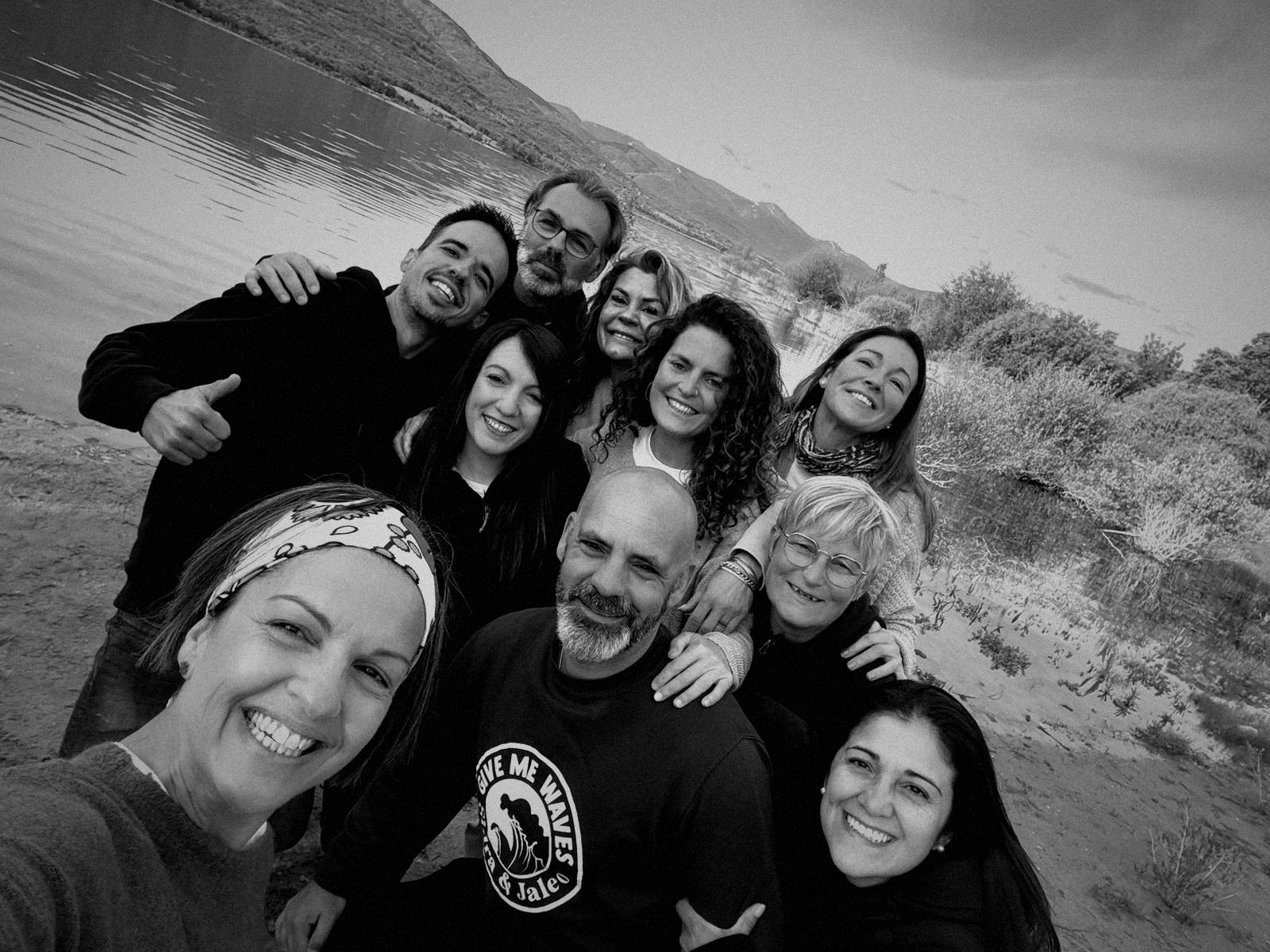 Un grupo de participantes abrazados junto al embalse, con la sierra al fondo
